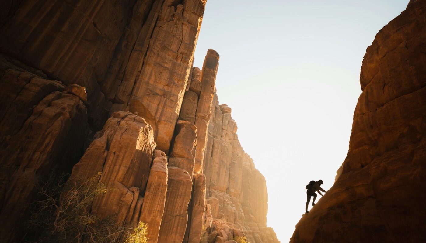 a man climbing up the side of a mountain